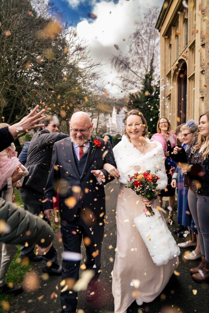 Bride and groom laughing together outside their Gloucestershire wedding venue after the ceremony